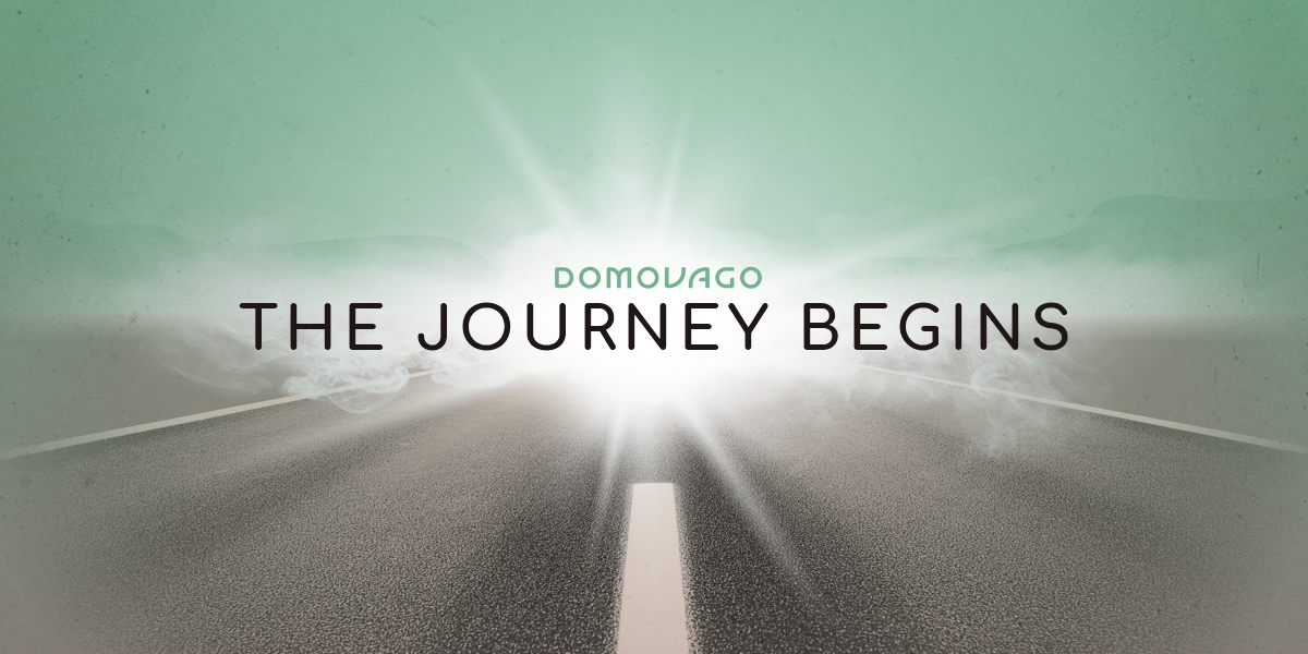 A road stretching into the distance with a bright light on the horizon. The text "DOMOVAGO - THE JOURNEY BEGINS" is overlaid on the image. Domovago mobile living, the journey begins on the open road.