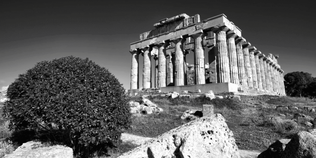 Ancient stone temple with classical columns under a clear sky, symbolizing the importance of remembering and honoring history.