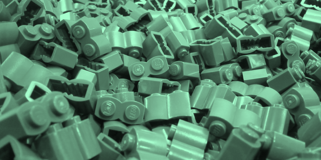 Pile of green LEGO bricks highlighting the modular system that allows endless combinations.